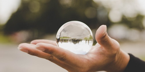 A hand holding a clear orb