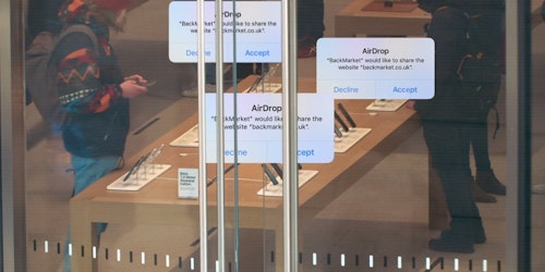 AirDrop messages promoting BackMarket, superimposed on top of an image of customers in an Apple Store