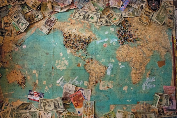 A world map surrounded by money