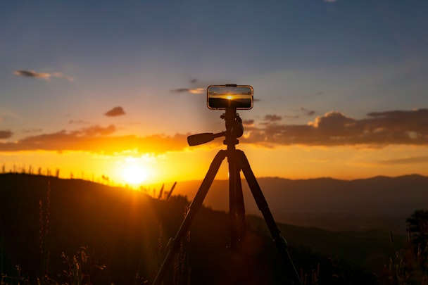 A phone set up to film a sunset