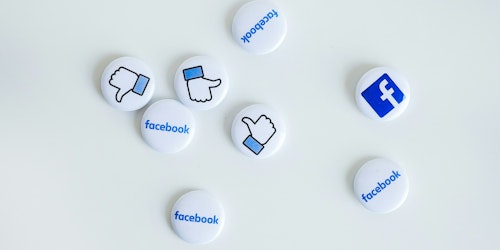 Facebook pin badges scattered on a white background