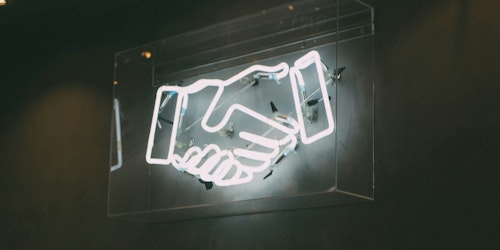 A neon sign of shaking hands