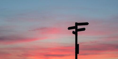 A signpost against a gradient sunset sky