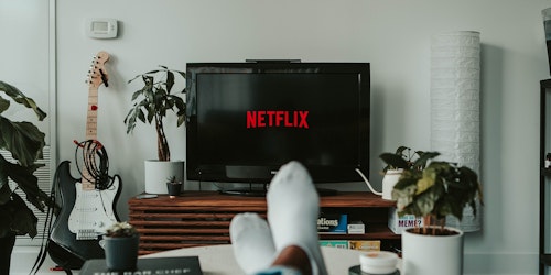 A pair of feet up on a coffee-table, watching Netflix