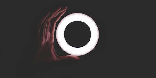 A hand shaping itself around the outside of a light-ring