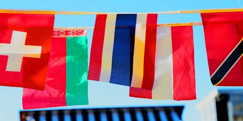 A row of small flags hanging in the sun