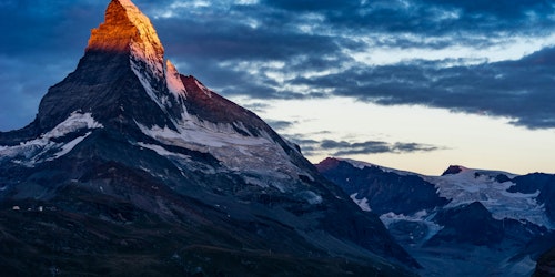 The sun-kissed snow-caps of a mountain