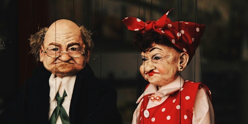 Two puppets, of an older man and an older woman