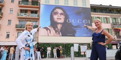 Two women point to an OOH ad at Cannes Lions Festival of Creativity