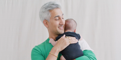 tan france holding a child