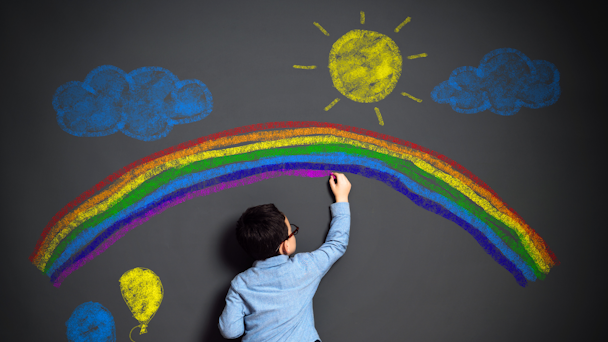 A child draws on a wall in chalk